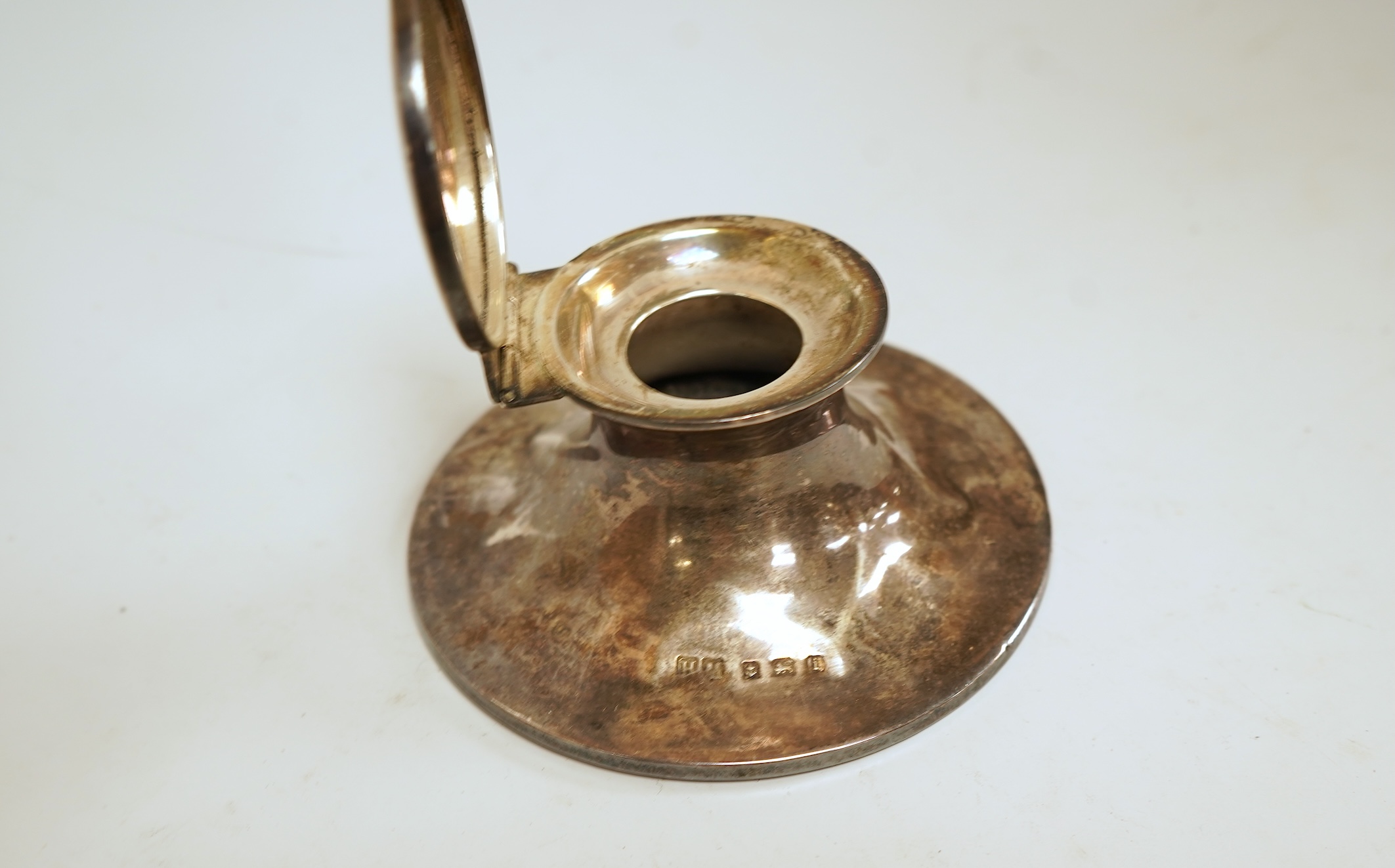 A small silver mounted capstan inkwell, a set of four George V engine turned silver napkin rings and a silver handled magnifying glass.